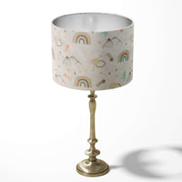 Nursery table and floor lampshade in green, orange and brown rainbow pattern on a white background.