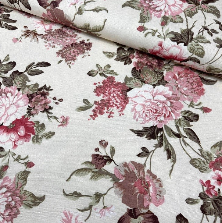 Pink flowers roses and green leaves printed on botanical cotton canvas upholstery fabric.