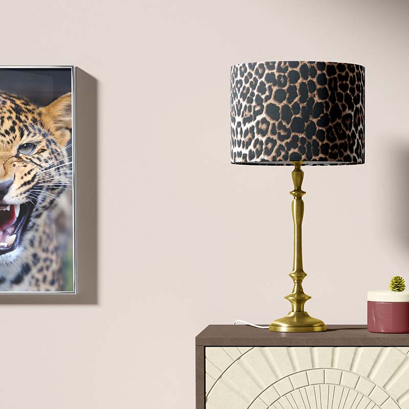 Table lamp with leopard print shade and a painting of a leopard on a wall