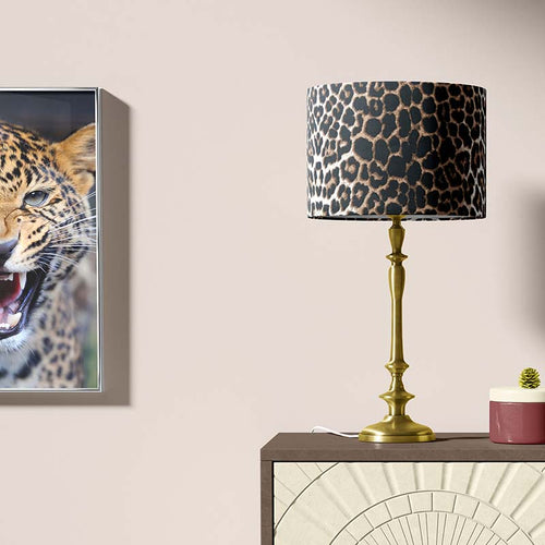 Table lamp with leopard print shade and a painting of a leopard on a wall