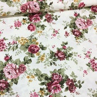 Vintage style floral garden upholstery fabric patterned with burgundy roses and sage green leaves.