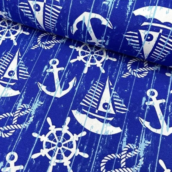 White boats, anchors, rope knots and ship wheels printed on night blue cotton canvas curtain upholstery fabric.