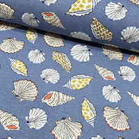 Nautical, coastal seashell print cotton upholstery curtain fabric in indigo blue, white, orange and yellow colours.
