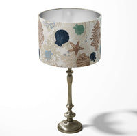 Sea shell and starfish ocean naytical table and floor lampshade in beige and blue.