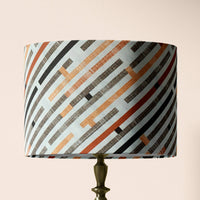 Table lamp shade with geometric pattern on a beige background.