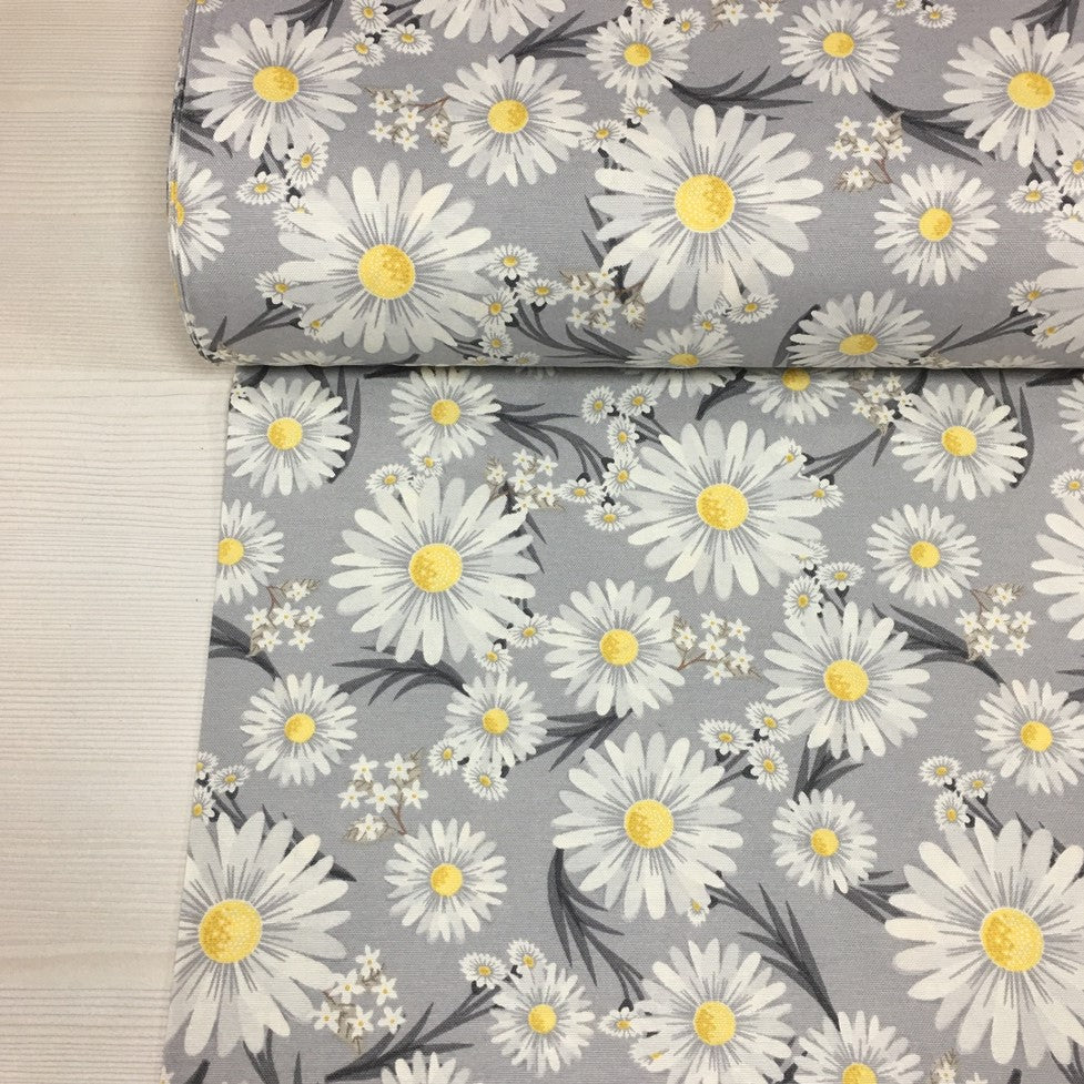 Cotton canvas upholstery fabric patterned with white flowers on a grey background.