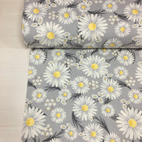 Cotton canvas upholstery fabric patterned with white flowers on a grey background.
