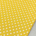 Yellow polka dot cotton canvas upholstery fabric with white spots on it